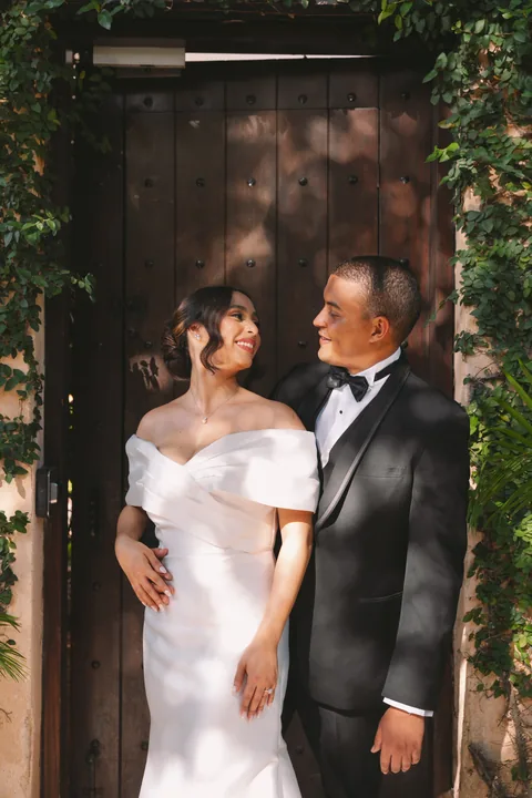 Pareja mirándose frente a una puerta de madera